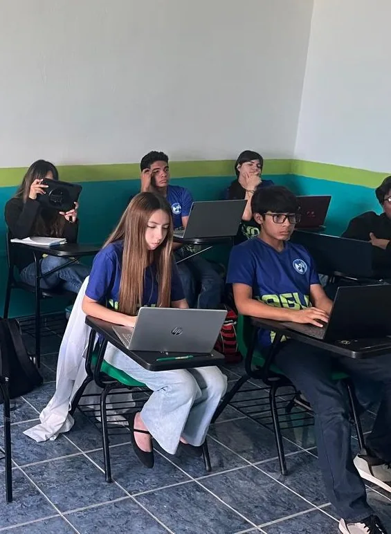 Estudiantes de Bachillerato de Colegio Latino usando laptops personales en el salón de clases