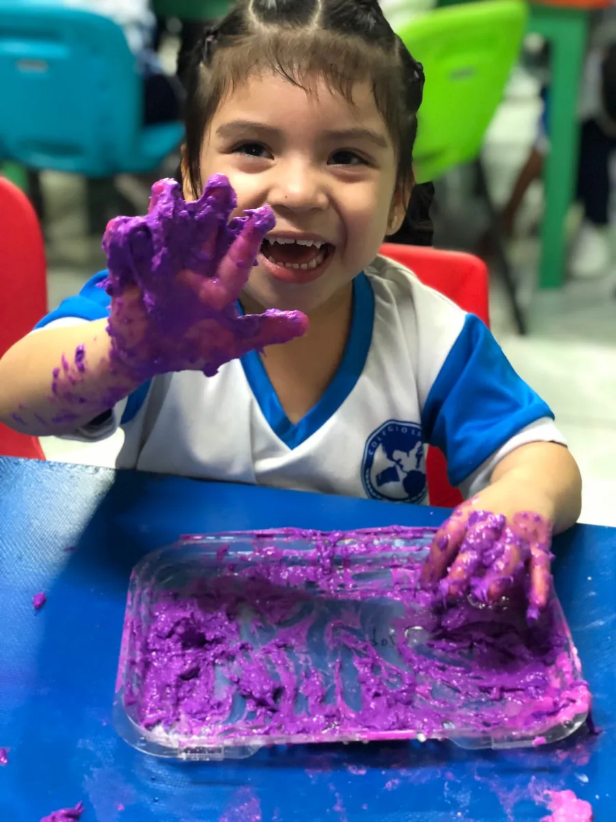 Estudiante de Preescolar de Colegio Latino explorando texturas con las manos en una actividad sensorial y creativa